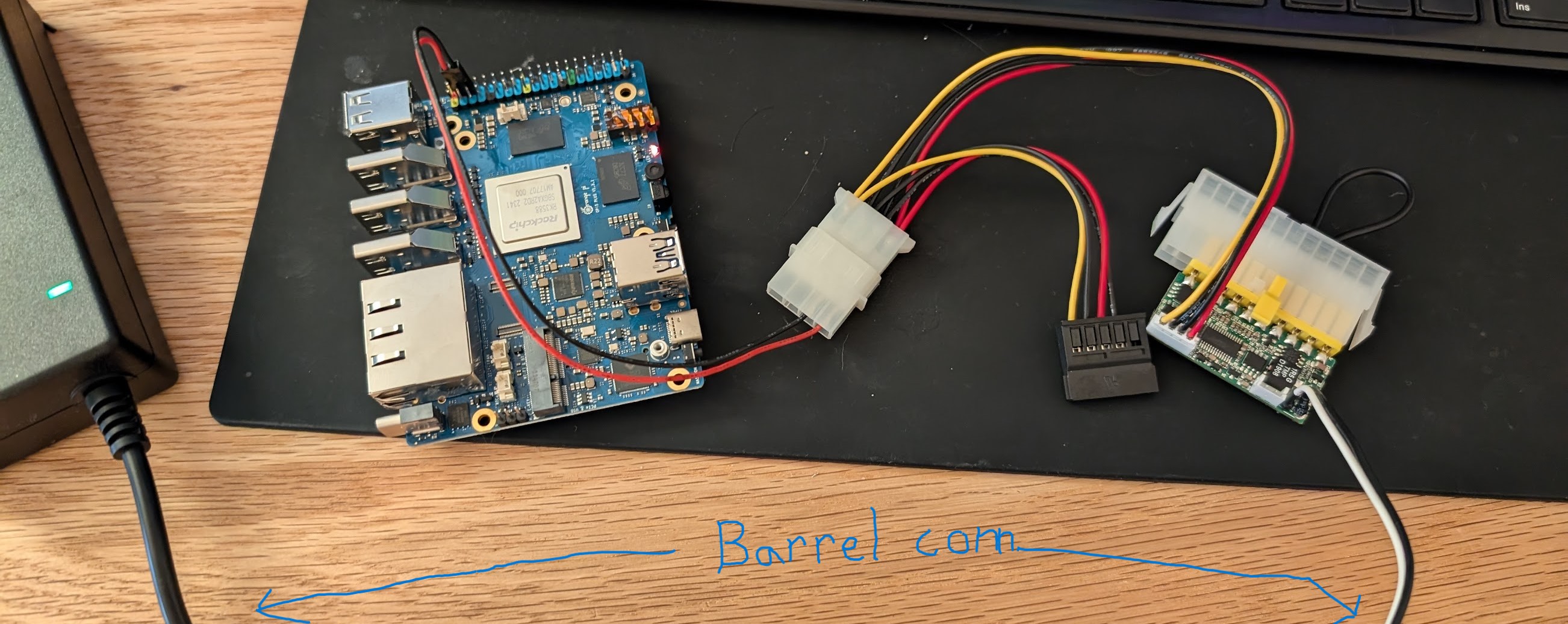 PSU bench test showing a power brick connected via barrel jack to a Pico PSU
which has an ATX jumper tool connected, and has a built-in cable extending off
for a molex connector that goes to the SBC and an extra SATA power
connector.