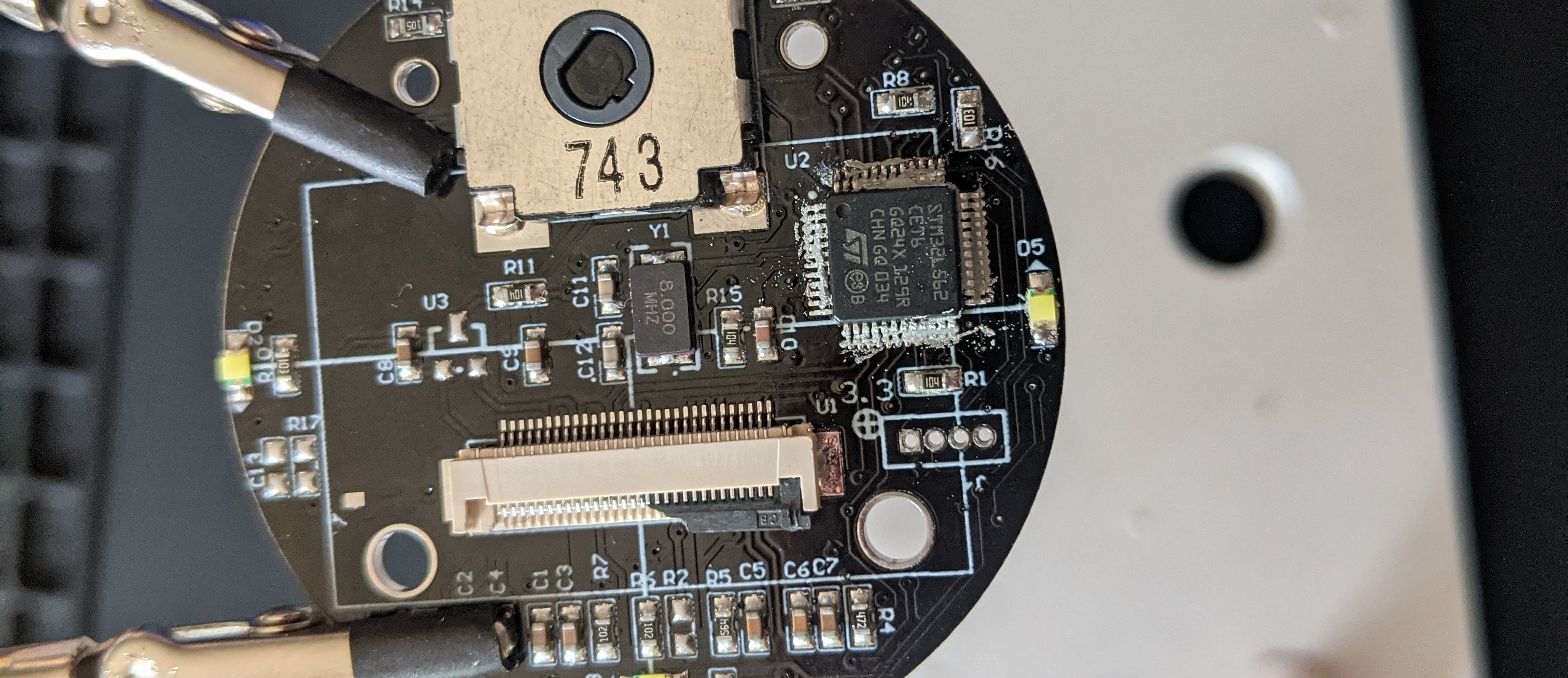 Photo of the board with a new STM32 chip placed on the pads, with solder paste applied